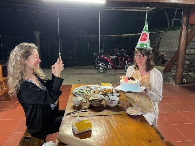Travelers enjoying traditional dinner with local family at homestay in Pu Luong Vietnam