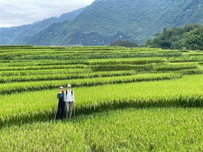 Travelers walking through rice terrace trekking trail in northern Vietnam