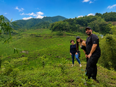 Travelers walking through Pu Luong rice terraces with a local guide during a 3 day trekking adventure